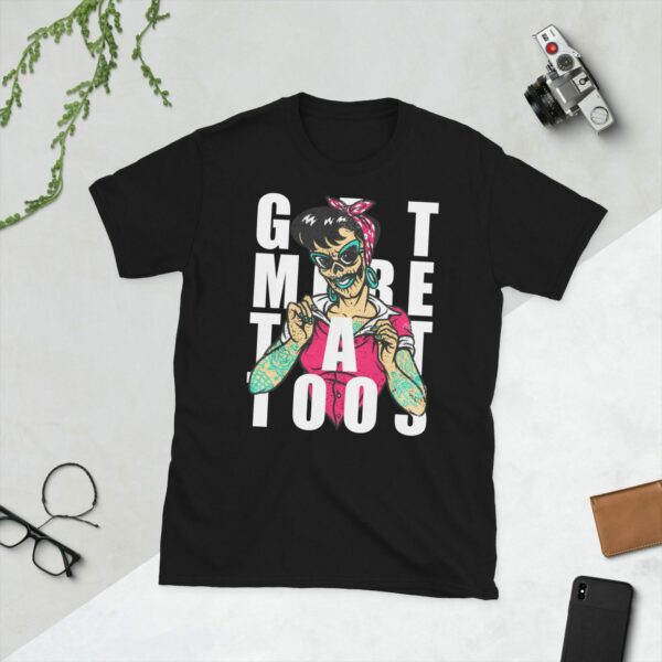 A black t-shirt showing a graphic of a tattooed lady with the slogan Get More Tattoos on it.