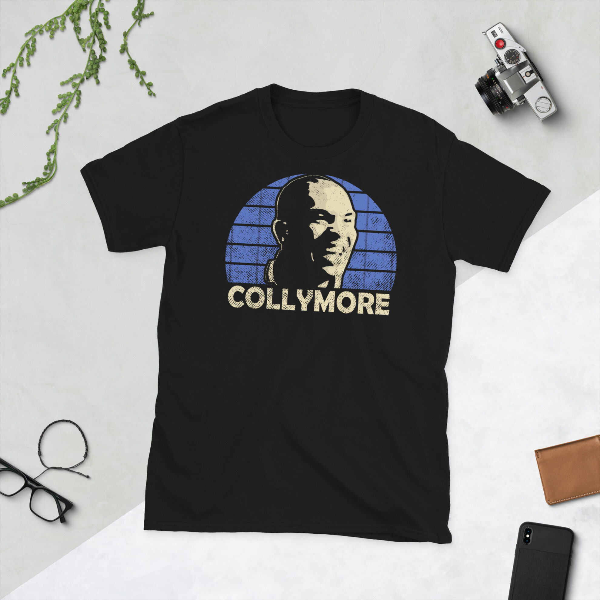 Stan Collymore Southend United T-Shirt in Black - A black T-shirt featuring a Southend United sunburst graphic and the word "COLLYMORE" in royal blue, honouring Southend United legend Stan Collymore.