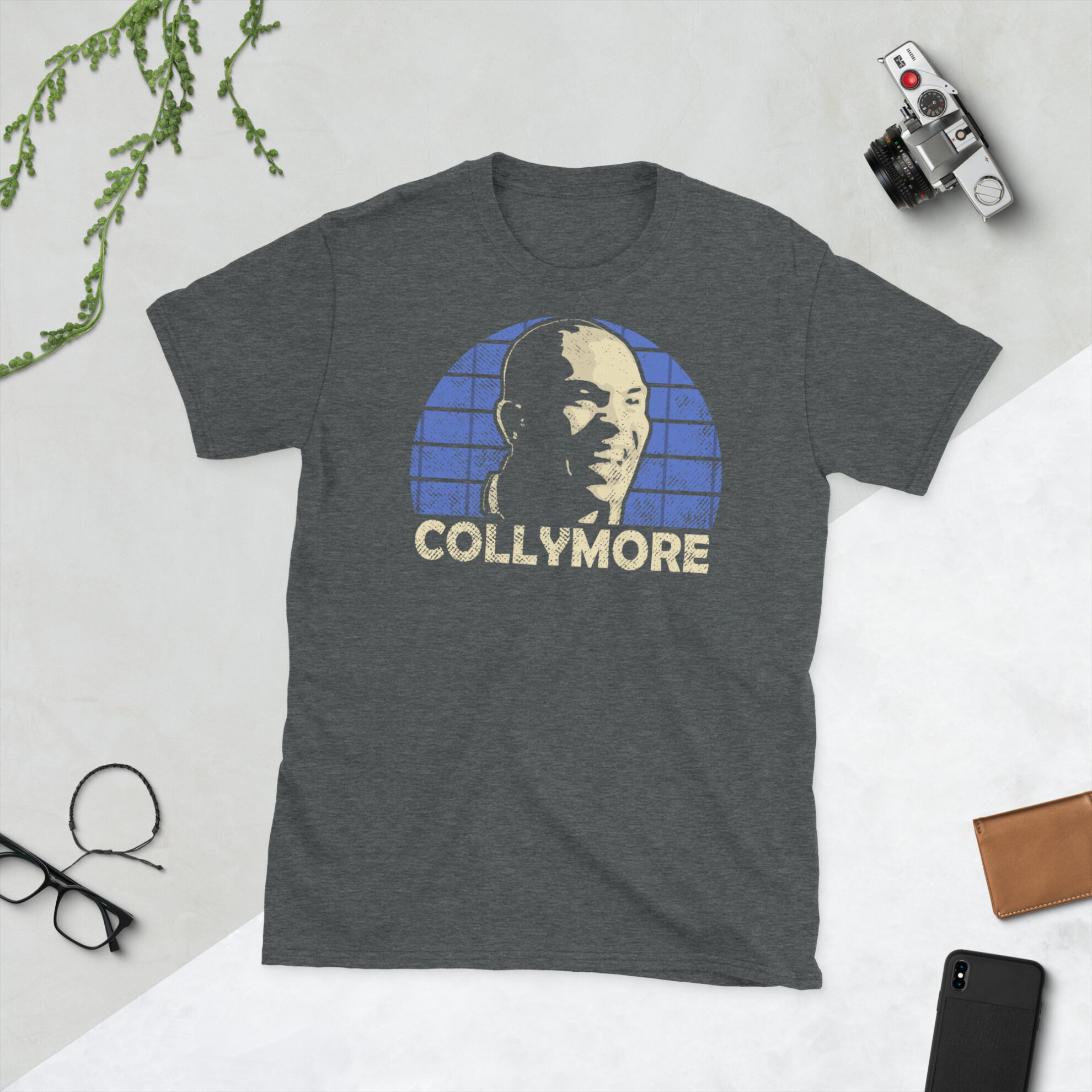 Stan Collymore Southend United T-Shirt in Heather - A heather grey T-shirt featuring a Southend United sunburst graphic and the word "COLLYMORE" in royal blue, commemorating Southend United legend Stan Collymore.