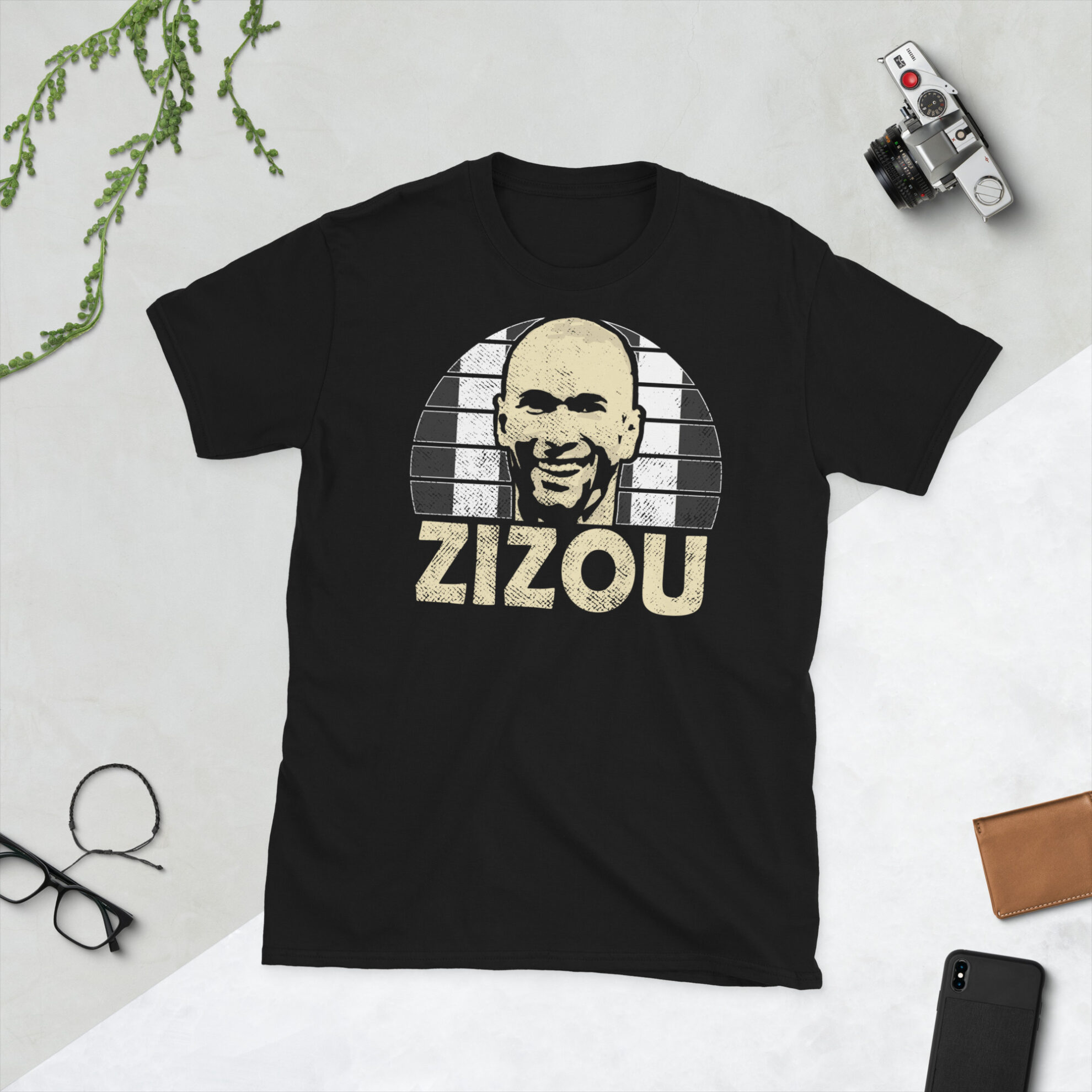 A black Zinedine Zidane Juventus FC t-shirt featuring a black and white striped sunburst design and the word "ZIZOU" printed prominently in bold.