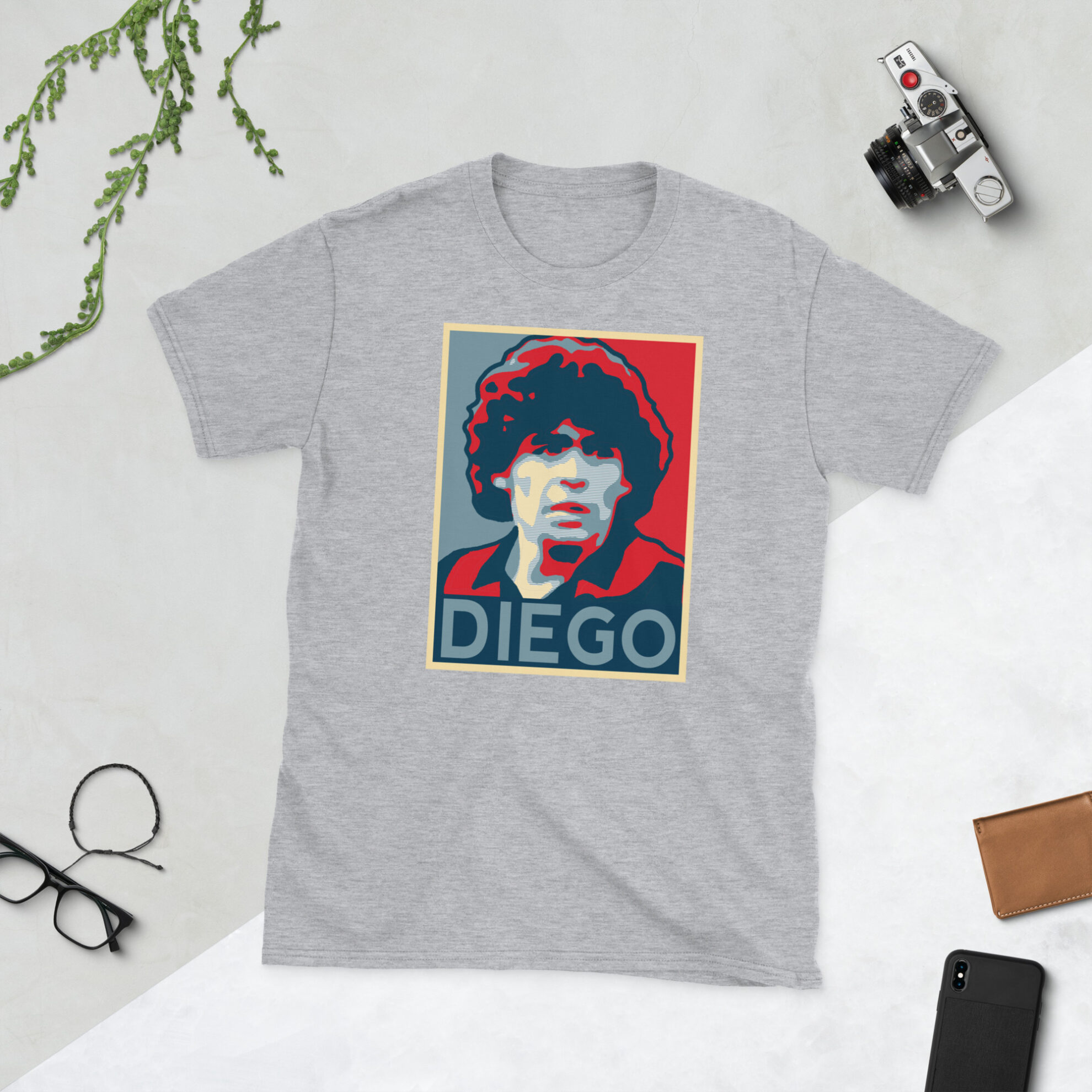 A grey Diego Maradona T-Shirt featuring a graphic portrait of Diego Maradona, similar to the Obama "HOPE" campaign poster, with "DIEGO" written below him in bold lettering.