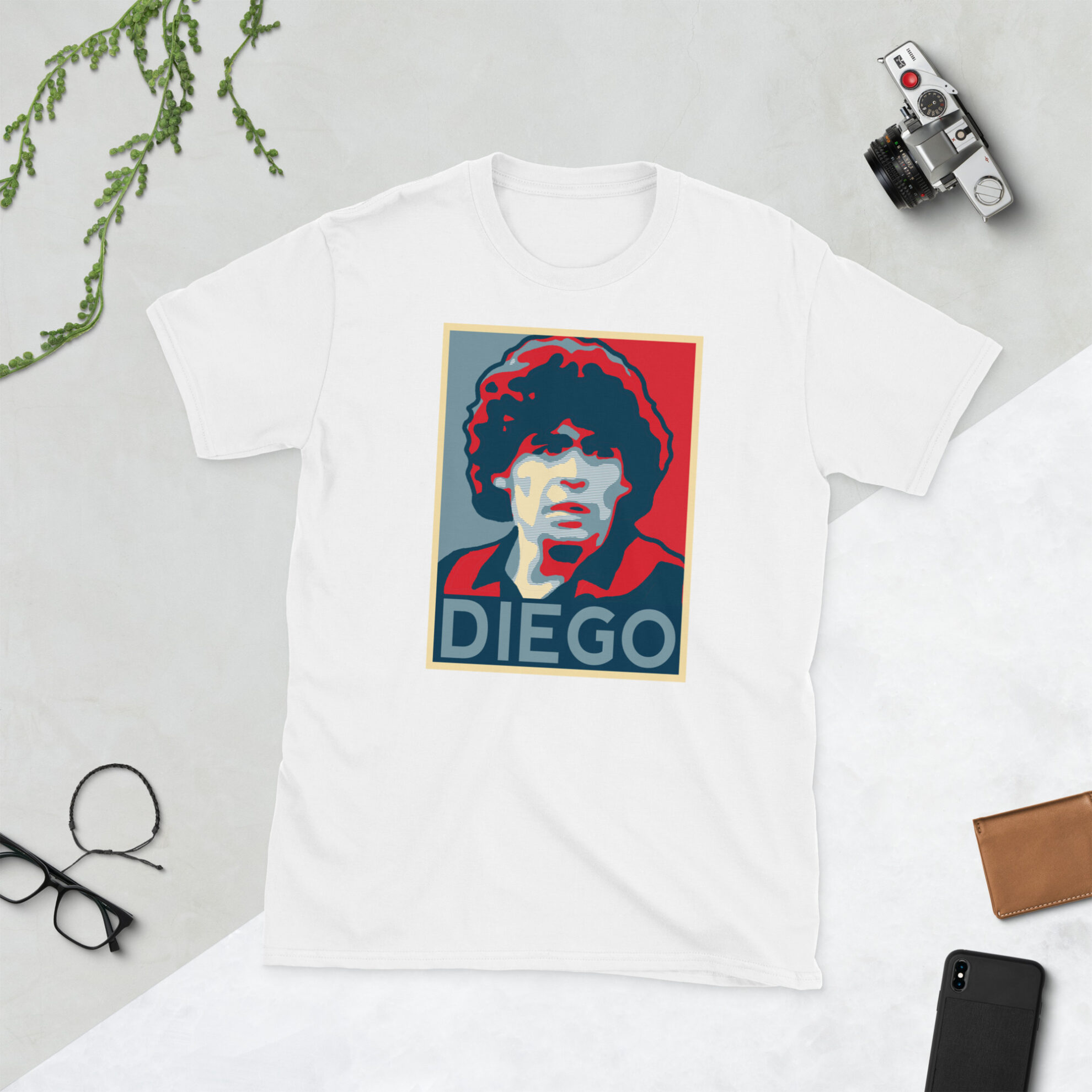 A white Diego Maradona T-Shirt featuring a graphic portrait of Diego Maradona, similar to the Obama "HOPE" campaign poster, with "DIEGO" written below him in bold lettering.