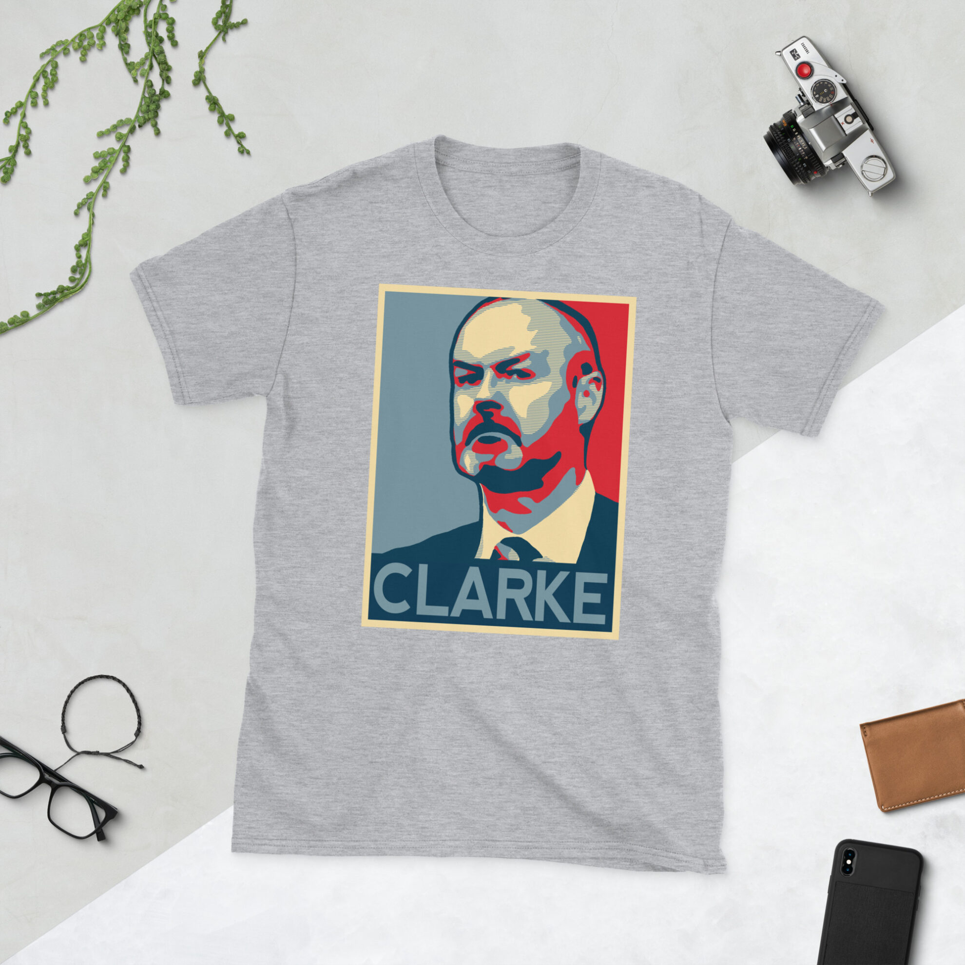 A grey Steve Clarke T-Shirt featuring a graphic portrait of Steve Clarke, similar to the Obama "HOPE" campaign poster, with "CLARKE" written below him in bold lettering.