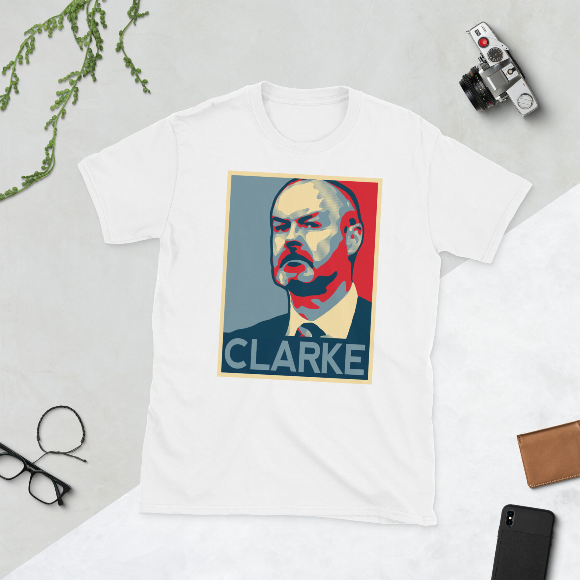 A white Steve Clarke T-Shirt featuring a graphic portrait of Steve Clarke, similar to the Obama "HOPE" campaign poster, with "CLARKE" written below him in bold lettering.