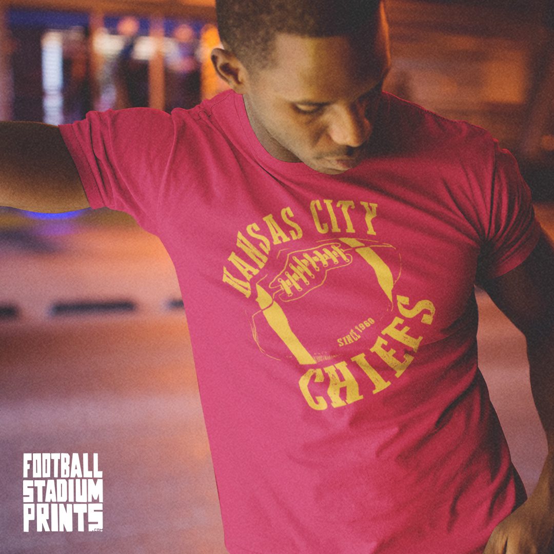 A man wearing a cardinal red t-shirt featuring a vintage graphic of the Kansas City Chiefs