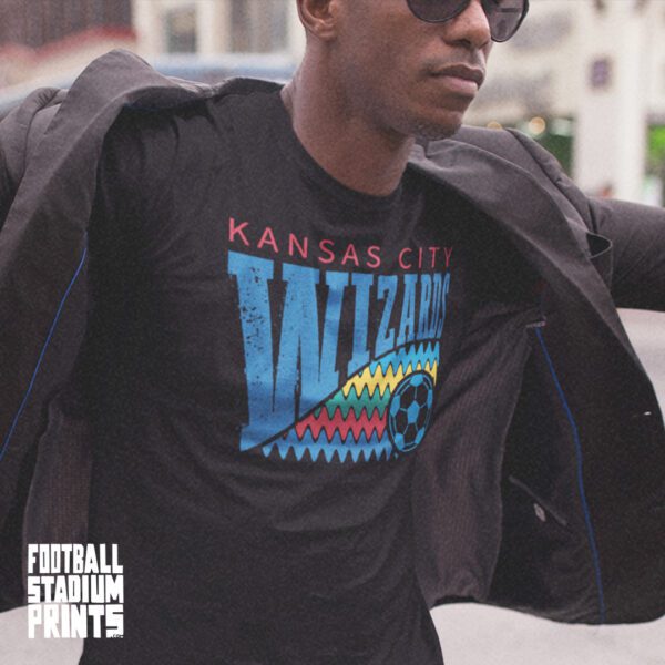 A man wearing a black t-shirt featuring a vintage graphic of the Kansas City Wizards