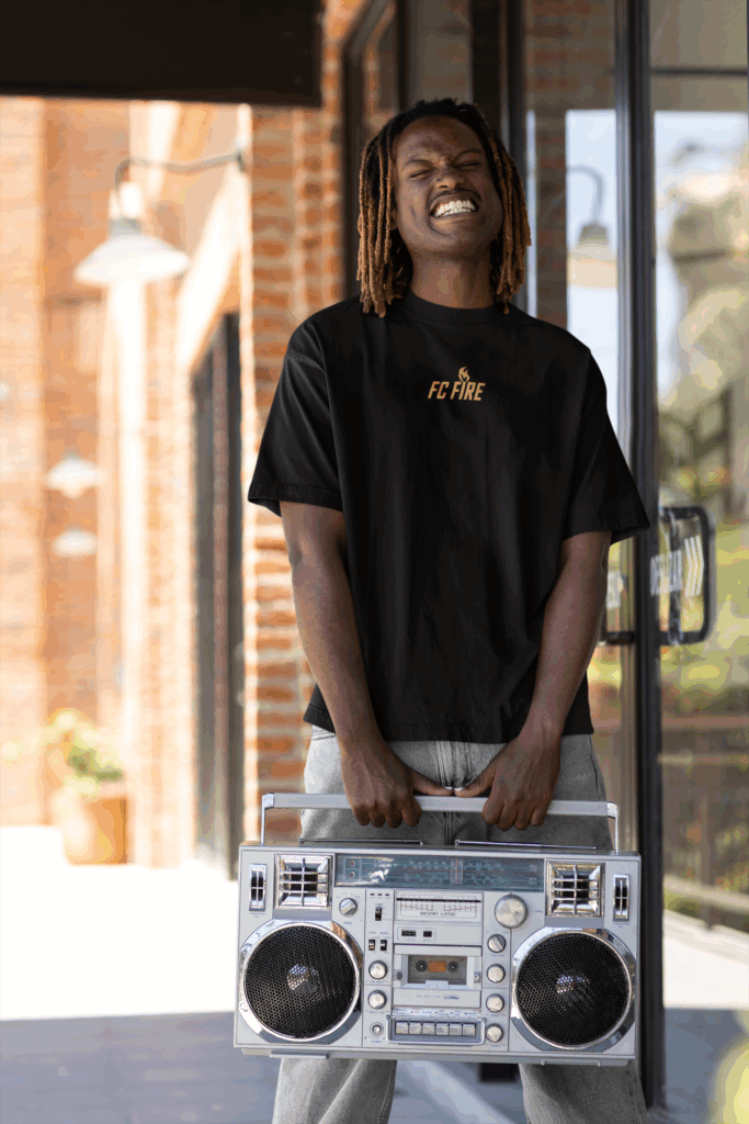 A smiling black guy with a boom box wearing a black FC Fire tee