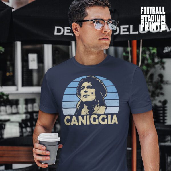 A man holding a cup of coffee wearing a navy t-shirt featuring Argentina football legend Claudio Caniggia