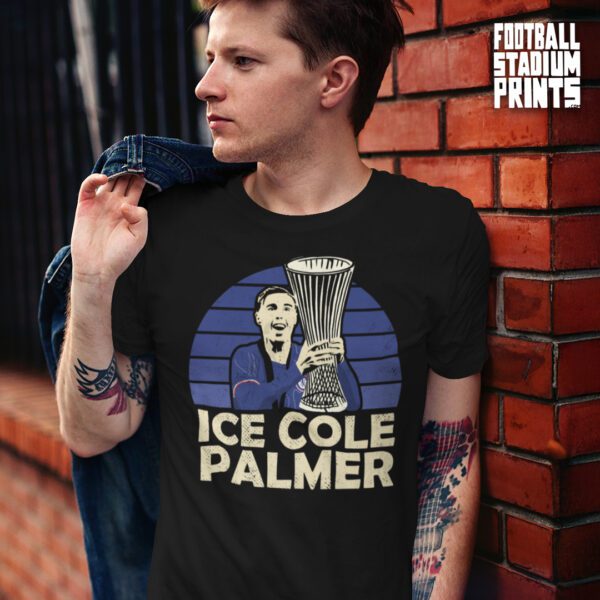 A man standing beside a red brick wall wearing a black t-shirt of Ice Cole Palmer, Chelsea player.