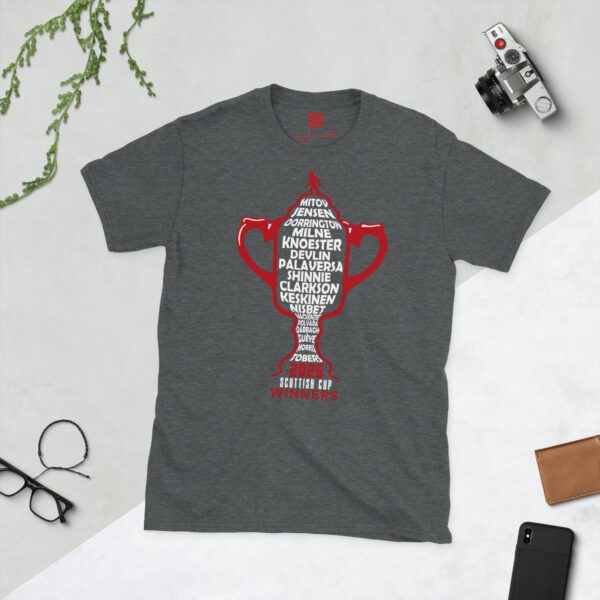 A dark heather T-shirt featuring a red outline of the Scottish Cup, with white text listing the names of every Aberdeen player from the 2025 Scottish Cup winning team, and "2025 SCOTTISH CUP WINNERS" below.