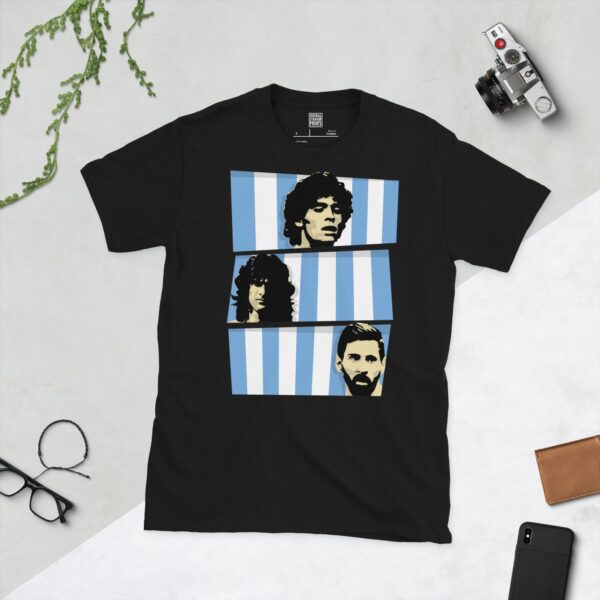 A black T-shirt featuring three stacked bands of blue and white stripes, each containing a stencil image of an Argentina World Cup winner: Diego Maradona, Mario Kempes, and Lionel Messi.