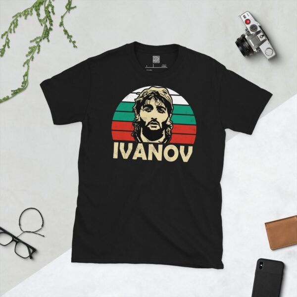 A striking black T-shirt showcasing a bold graphic of Trifon Ivanov's distinctive face set against a retro sunburst featuring the white, green, and red stripes of the Bulgarian flag. Below his image, his surname "IVANOV" is prominently displayed.