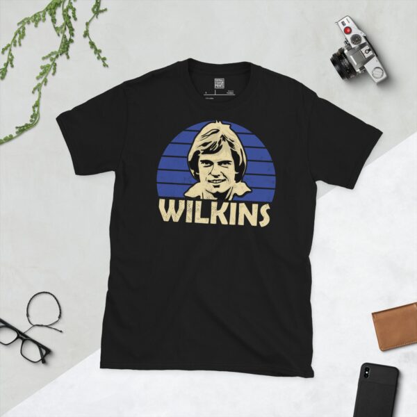 A black Ray Wilkins T-shirt featuring a blue sunburst design with "WILKINS" written under the main graphic.