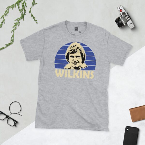 A sports grey Ray Wilkins T-shirt featuring a blue sunburst design with "WILKINS" written under the main graphic.