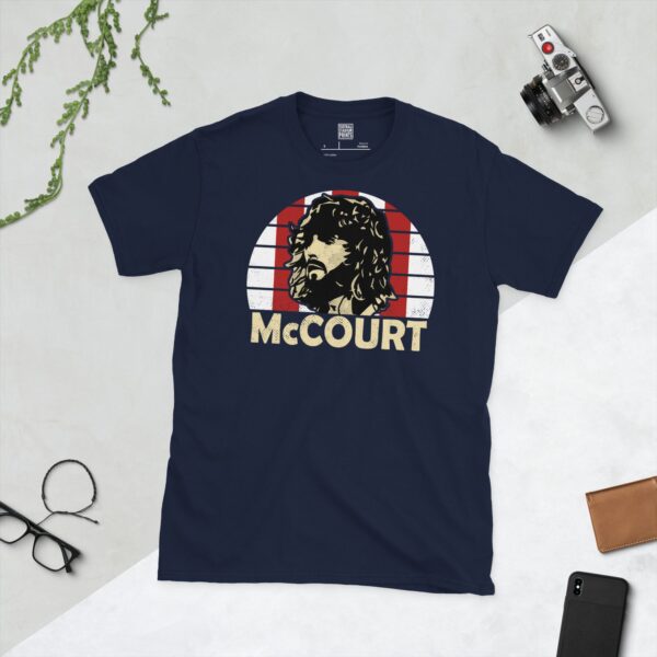 Celebrate Derry City legend Paddy McCourt with this navy blue tee. It features a striking red and white striped sunburst design with "McCOURT" written under the main graphic.