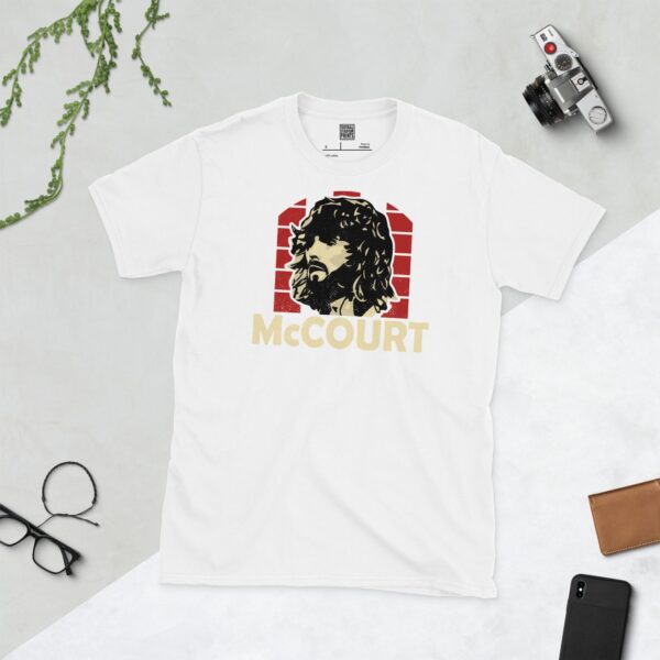 Show your Derry City pride in this white Paddy McCourt T-shirt. It features a red and white striped sunburst design with "McCOURT" written under the main graphic.