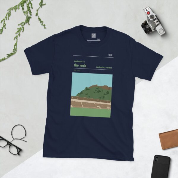 A deep navy blue T-shirt showcasing a stylised illustration of Dumbarton's iconic 'Rock' landmark overlooking the football pitch. The design includes the club's name, location, and founding year of 1872.