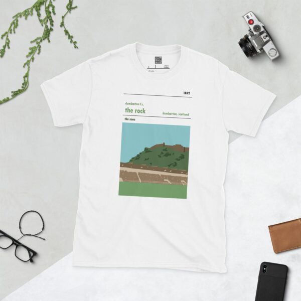 A clean white T-shirt showcasing a clear, illustrative graphic of Dumbarton Rock and the football club's ground. The design highlights "dumbarton f.c.", "the rock", "the sons", and "1872".