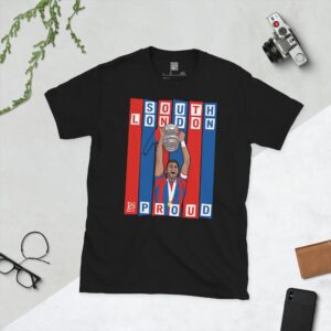 A black T-shirt featuring a graphic of Crystal Palace legend Joel Ward lifting the FA Cup, set against bold blue and red stripes. The text "SOUTH LONDON" is at the top and "AND PROUD" is at the bottom.