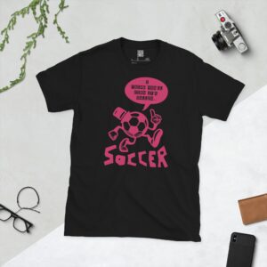 A black T-shirt featuring a pink cartoon football character with a top hat, arms, and legs, pointing. A speech bubble above reads "I THINK YOU'LL FIND IT'S CALLED..." and "SOCCER" is written below the character.