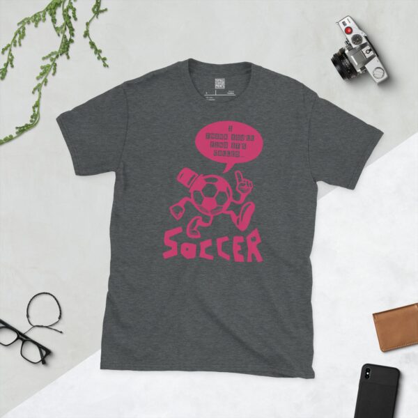 A dark heather T-shirt featuring a pink cartoon football character with a top hat, arms, and legs, pointing. A speech bubble above reads "I THINK YOU'LL FIND IT'S CALLED..." and "SOCCER" is written below the character.