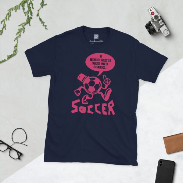A navy T-shirt featuring a pink cartoon football character with a top hat, arms, and legs, pointing. A speech bubble above reads "I THINK YOU'LL FIND IT'S CALLED..." and "SOCCER" is written below the character.