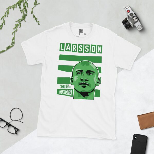 A crisp white T-shirt featuring a stylised graphic of Celtic legend Henrik Larsson's face, positioned against bold green and white horizontal stripes, with "LARSSON" in block letters above and "KING OF KINGS" below the portrait.