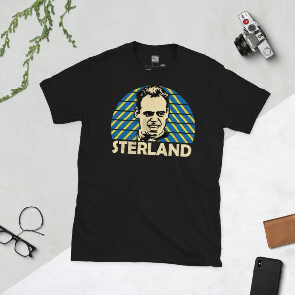 A bold black T-shirt emblazoned with a stylised portrait of Mel Sterland, a key figure from Leeds United's past. The background features a striking blue and yellow sunburst pattern, matching the team's badge, and his name "STERLAND" is placed beneath the image.
