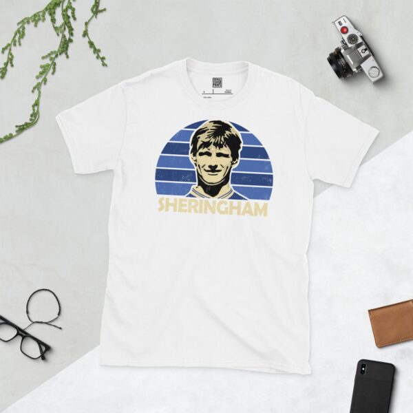 Show your Millwall pride in this white Teddy Sheringham T-shirt. It features a blue sunburst design with "SHERINGHAM" written under the main graphic.
