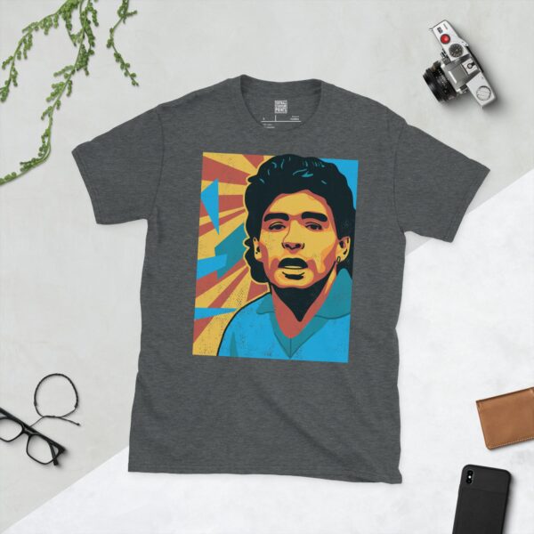 A dark heather T-shirt featuring a colourful, distressed graphic of Diego Maradona with a blue shirt and yellow and red background elements.