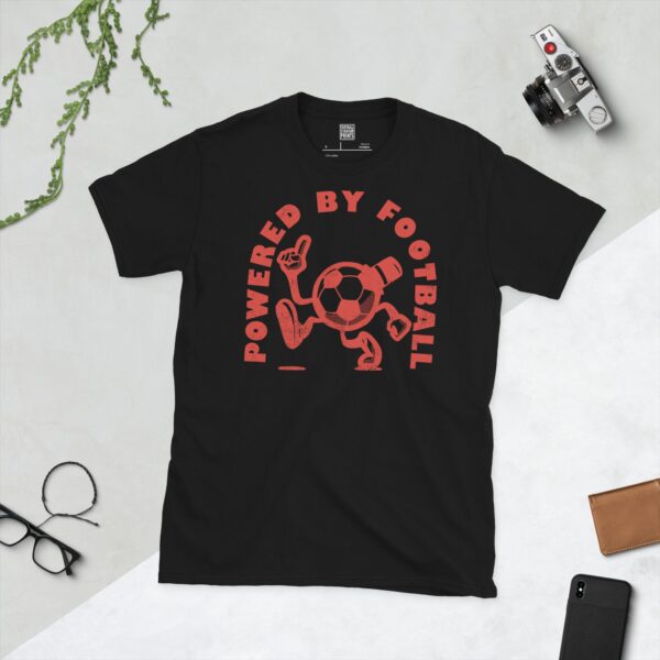 A black T-shirt featuring a distressed red graphic of a cartoon football character with a top hat, arms, and legs, pointing upwards. The text "POWERED BY FOOTBALL" is arranged in a circular design around it.