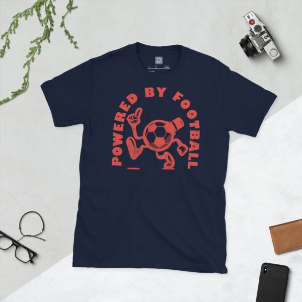 A navy T-shirt featuring a distressed red graphic of a cartoon football character with a top hat, arms, and legs, pointing upwards. The text "POWERED BY FOOTBALL" is arranged in a circular design around it.