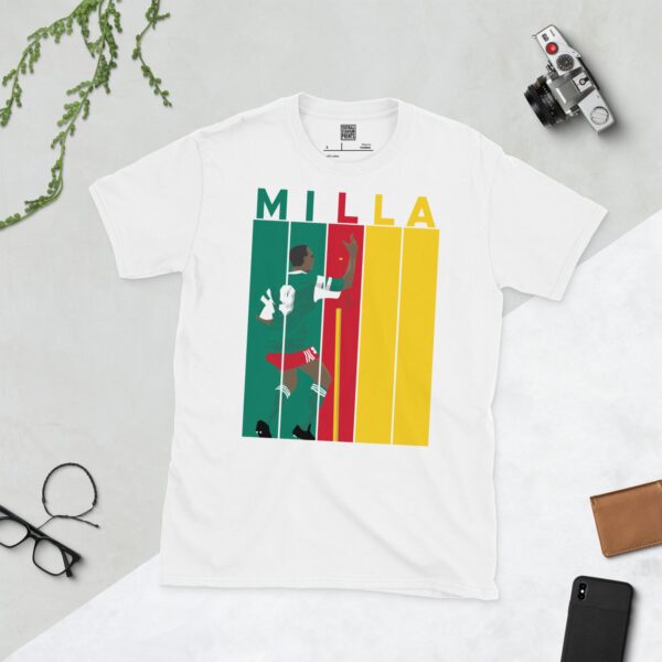 Show your appreciation for Roger Milla with this white T-shirt. It features a bold striped design in Cameroon flag colours, with "MILLA" above five pillars and a graphic of Roger Milla doing his iconic corner flag dance from the 1990 World Cup.
