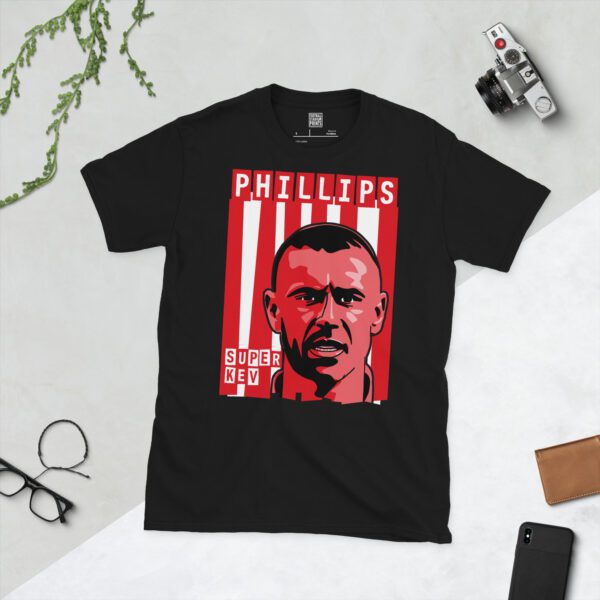 A bold black T-shirt displaying a vivid illustration of Sunderland icon Kevin Phillips's face. Behind him are classic red and white vertical stripes, evoking the iconic Black Cats kit. His surname "PHILLIPS" and the famous nickname "SUPER KEV" are prominently featured in block letters.