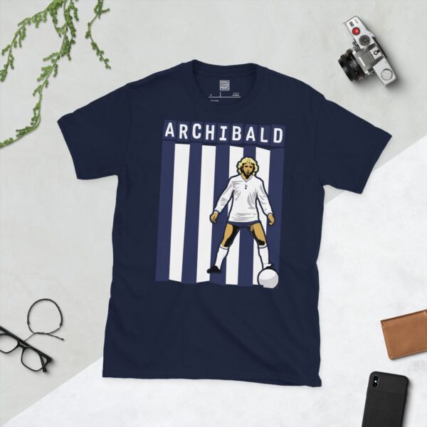 A deep navy blue T-shirt featuring a compelling graphic of Steve Archibald, the legendary Tottenham Hotspur forward, with his image set against bold navy and white vertical stripes. His iconic surname "ARCHIBALD" is clearly visible, paying tribute to his time at the club.