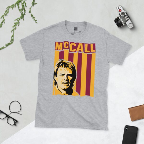 A versatile sports grey T-shirt showcasing a dynamic illustration of Stuart McCall, the beloved Bradford City captain. The design includes his portrait over a bold claret and amber striped pattern, with "MCCALL" clearly visible above.