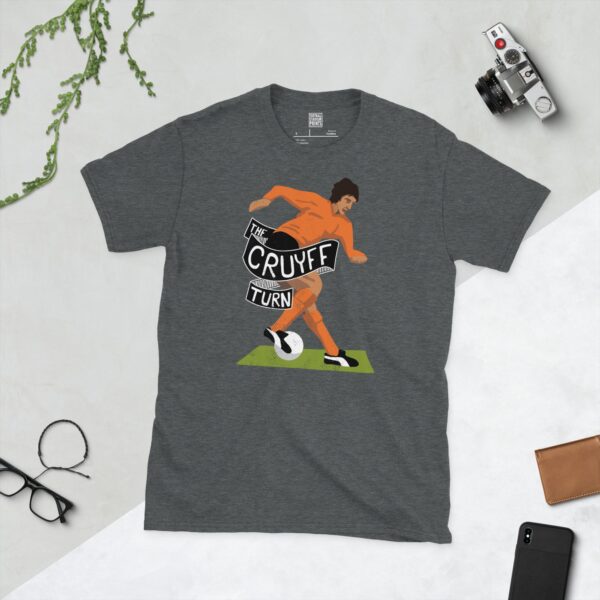 A subtle dark heather T-shirt displaying a distinctive graphic of former football maestro Johan Cruyff. The design shows him mid-'Cruyff Turn' with the phrase "THE CRUYFF TURN" to immortalise one of football's most famous tricks.