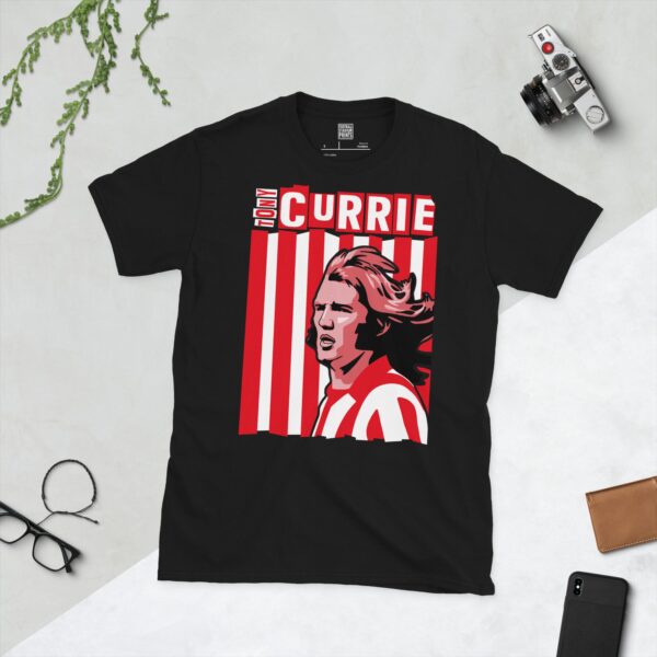 A bold black T-shirt emblazoned with a striking portrait of Sheffield United icon Tony Currie. The graphic depicts his face against a backdrop of red and white stripes, and his name is a central feature.