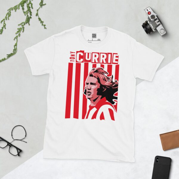 A clean white T-shirt featuring a stylized graphic of Sheffield United legend Tony Currie, set against a background of red and white vertical stripes. His name "TONY CURRIE" is prominently displayed on the graphic.