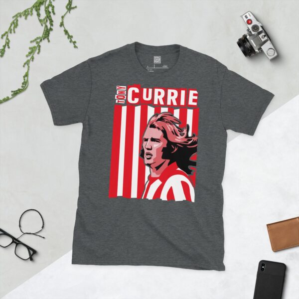 A subtle dark heather T-shirt displaying a distinctive graphic of former Sheffield United maestro Tony Currie. His portrait is captured against a retro red and white striped backdrop, with his name directly incorporated into the design.