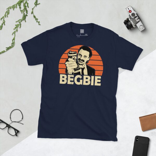 A deep navy blue T-shirt featuring a compelling graphic of Francis Begbie, the notorious character from Trainspotting. His image is set against a vivid orange sunburst design with "BEGBIE" clearly visible, paying tribute to his influential role.
