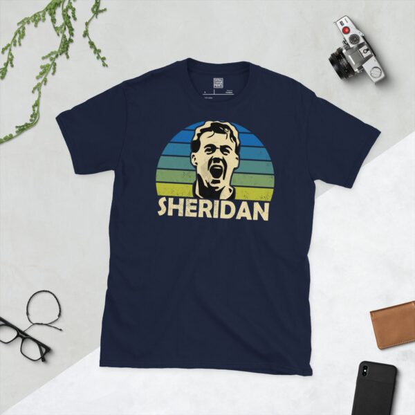 A deep navy blue T-shirt featuring a compelling graphic of John Sheridan, the legendary Leeds United player, with his image set against a vivid sunburst design that fades from blue to yellow. His iconic surname "SHERIDAN" is clearly visible, paying tribute to his time at the club.