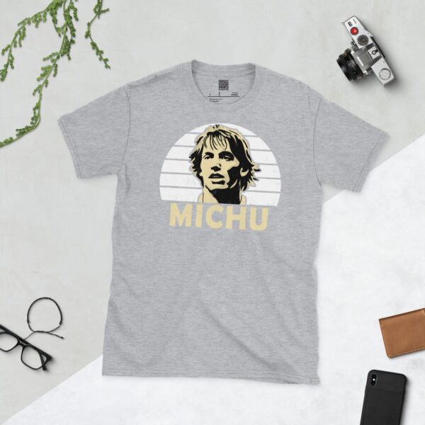 A versatile sports grey T-shirt showcasing a dynamic illustration of Michu, the beloved Swansea City striker. The design includes his portrait over a bold white radiating pattern, with "MICHU" clearly visible underneath.