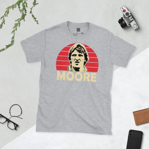 A versatile sports grey T-shirt showcasing a dynamic illustration of Ronnie Moore, the beloved Rotherham United manager and player. The design includes his portrait over a bold red radiating pattern, with "MOORE" clearly visible underneath.
