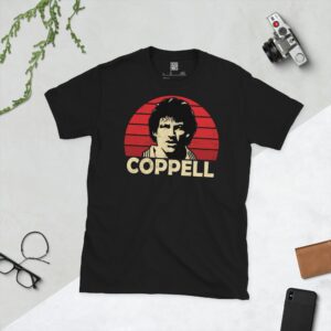 A bold black T-shirt emblazoned with a striking portrait of Manchester United icon Steve Coppell. The graphic depicts his face against a backdrop of red sunburst lines, and his surname "COPPELL" is a central feature below the image.