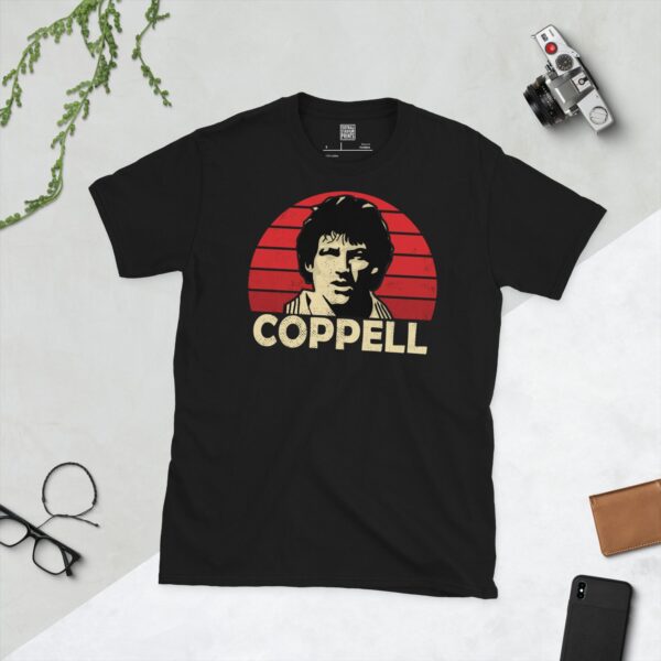 A bold black T-shirt emblazoned with a striking portrait of Manchester United icon Steve Coppell. The graphic depicts his face against a backdrop of red sunburst lines, and his surname "COPPELL" is a central feature below the image.