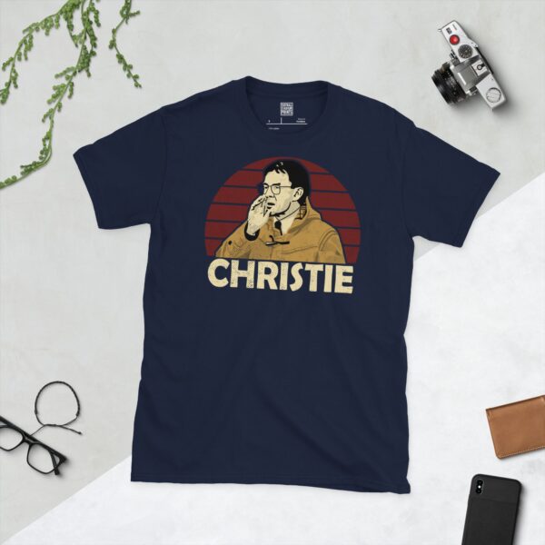 A deep navy blue T-shirt featuring a compelling graphic of Terry Christie, the legendary Stenhousemuir manager, with his image set against a vivid burgundy sunburst design. His iconic surname "CHRISTIE" is clearly visible, paying tribute to his time at the club.