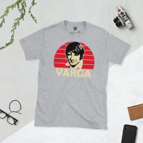 A sports grey T-shirt showcasing a portrait of Dons icon Zoltan Varga over a red sunburst background. The surname "VARGA" is printed in light yellow below the illustration.