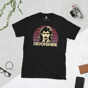 A black T-shirt featuring a stylised graphic of West Ham United legend Alan Devonshire's profile, set against a claret striped sunburst background. The name "DEVONSHIRE" is printed in light yellow below the portrait.