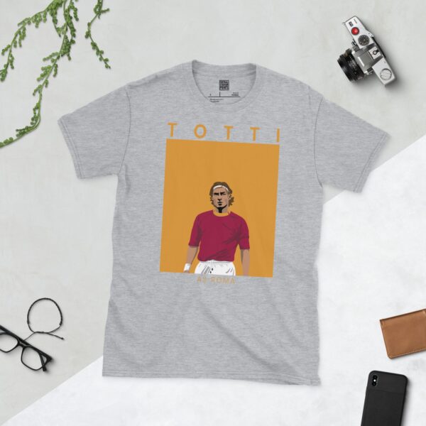 A sports grey T-shirt featuring a unique graphic of Francesco Totti, the one-club AS Roma icon. The text "TOTTI" is above his image and "AS ROMA" is below.